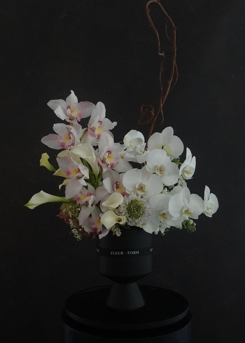 Bouquet of flowers in a black vase against a dark background
